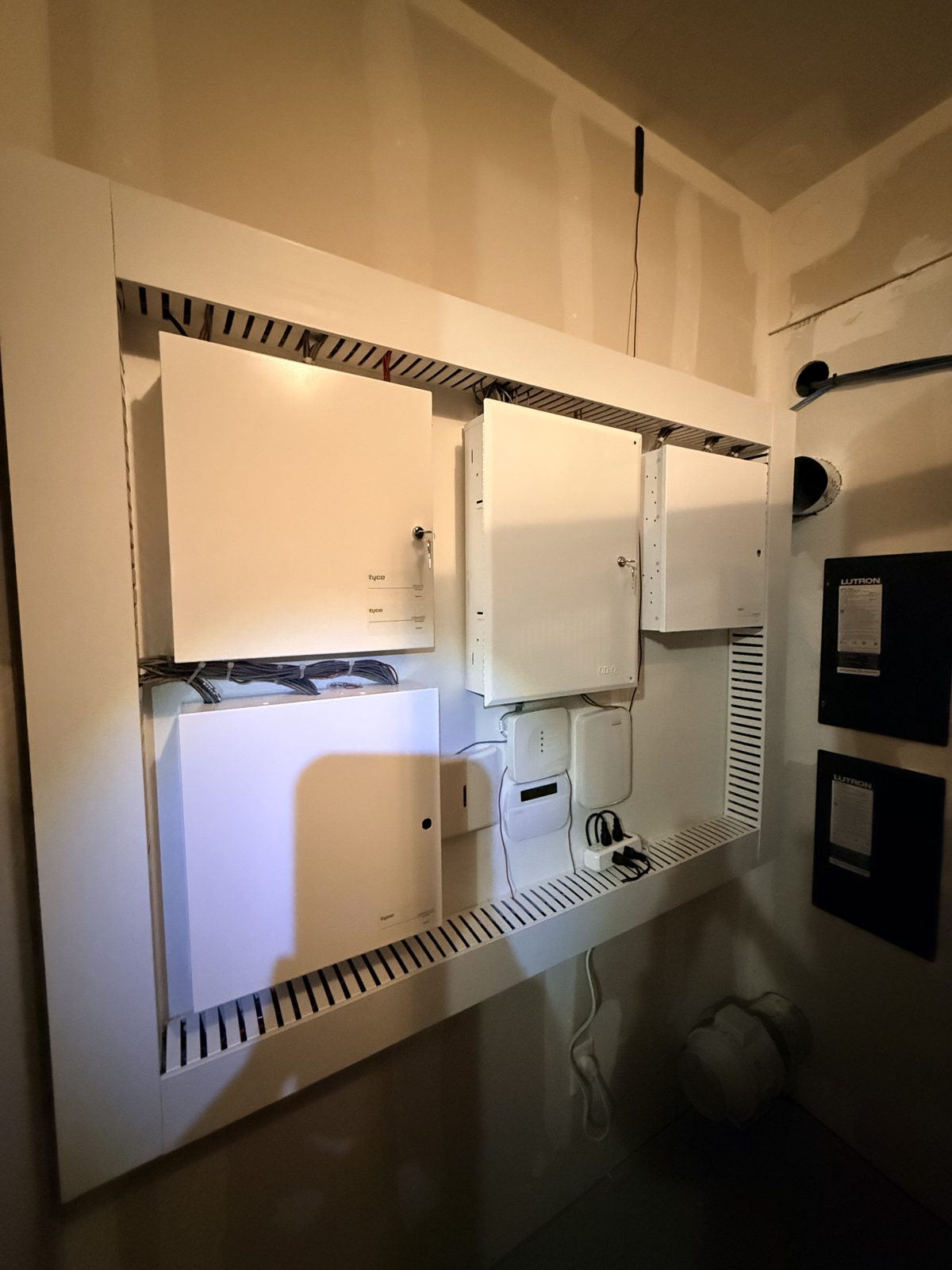The same wall after HPSI cleanup: organized enclosures mounted on a framed board
