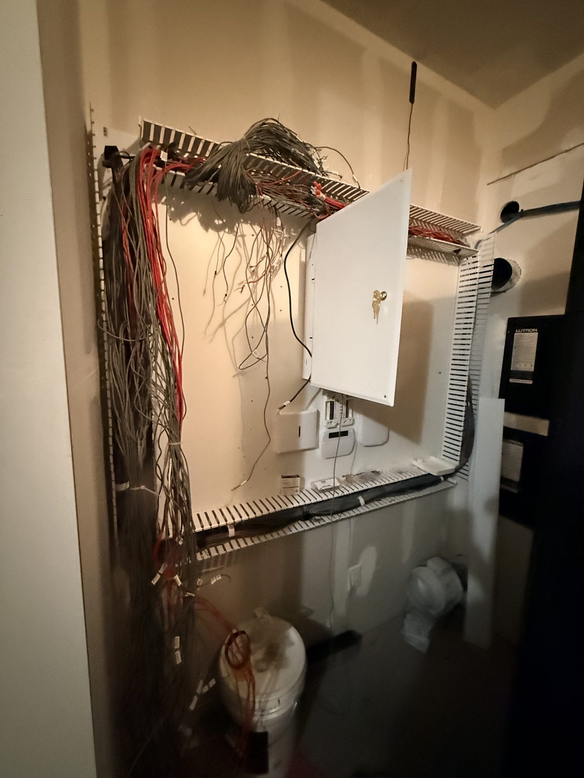 Tangled legacy low-voltage wiring around an open panel before HPSI cleanup