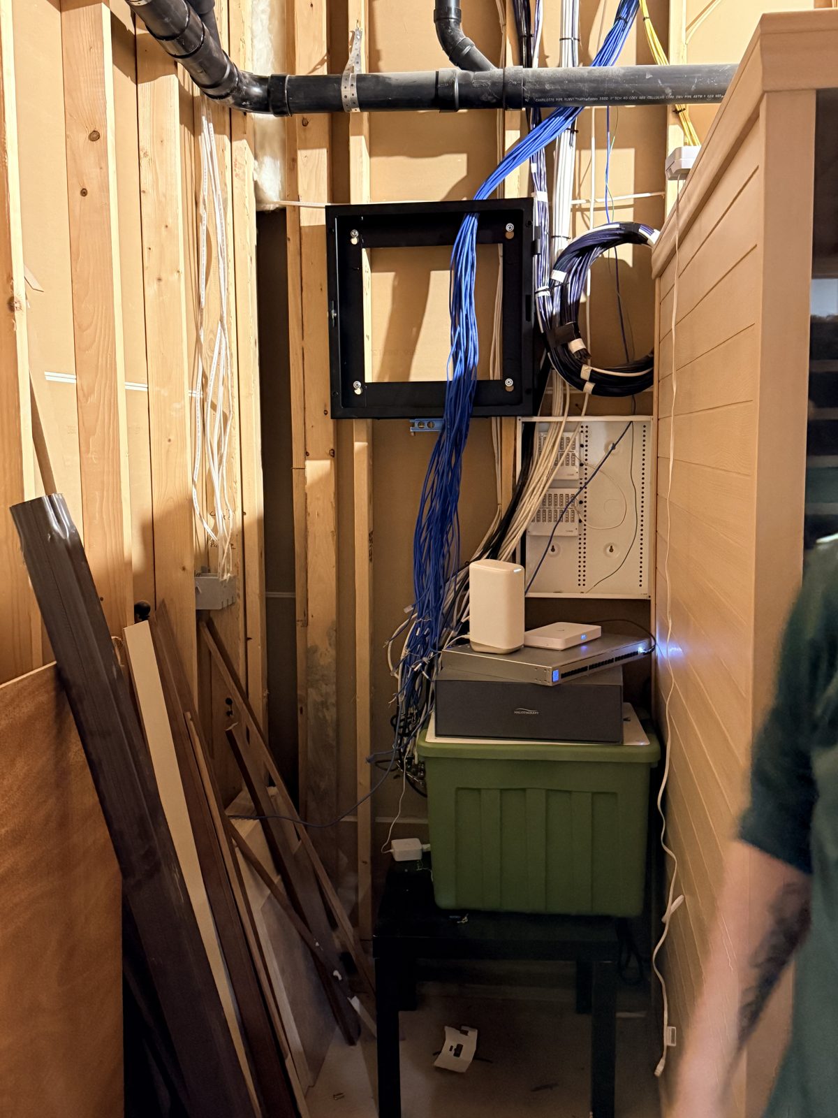 Network head end mid-construction with Cat6 bundles and enclosure frame during rough-in